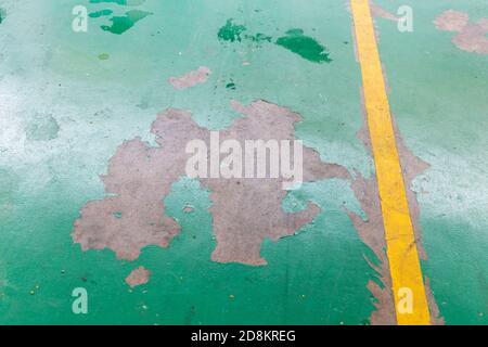 Peeling damaged epoxy layered flooring of workshop in garage Stock Photo