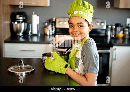 A Nice little kid in chef hat at kitchen Stock Photo