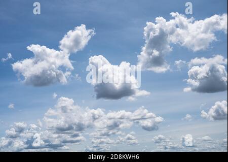 White fluffy clouds in blue sky on bright day Stock Photo