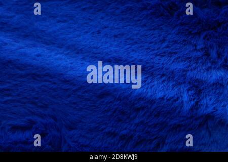 Fluffy soft texture of colored wool of a trendy, saturated dark blue color with real diagonal sunlight. Stock Photo