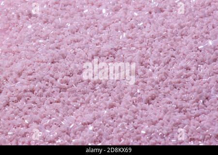 Beautiful set of red and purple beads in a transparent box on a gentle fluffy pink background decorated with red sparkling sequins. Stock Photo