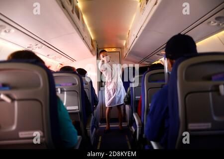 Pokhara, Nepal. 29th Oct, 2020. A flight attendant of Buddha Air in protective suit gestures safety signs during a flight amid the coronavirus pandemic at Pokhara Airport in Pokhara, Nepal on Saturday, October 31, 2020. Credit: Skanda Gautam/ZUMA Wire/Alamy Live News Stock Photo