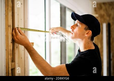 A handsome young man installing Double Sliding Patio Door in a new house construction site Stock Photo