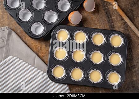 Cupcake butter in metal tray, ready to be bake on wooden background, tp view Stock Photo