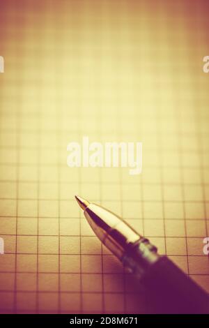 Part of an ballpoint pen on a notepad in a cage Stock Photo