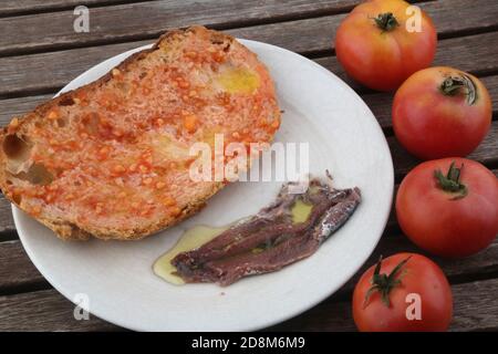 tomatoes and tomato bread with anchovies and olive oil as typical spanish food Stock Photo