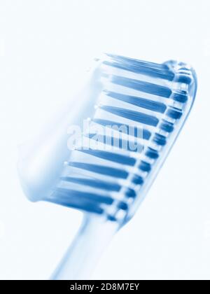 Two blue plastic toothbrushes with toothpaste on white art background. Stock Photo