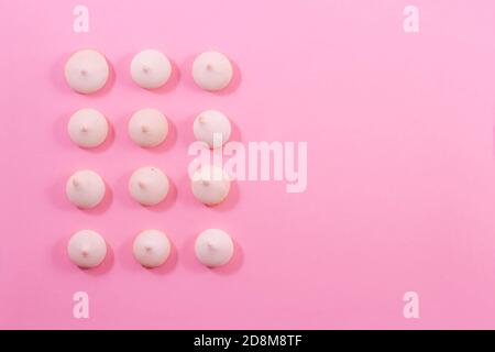 Zephyr cookies laid out with a vertical row on a light gentle pink-red background. Stock Photo