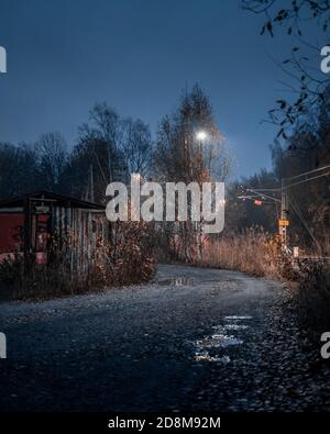 Autumn night scene of a dirt road and puddles Stock Photo