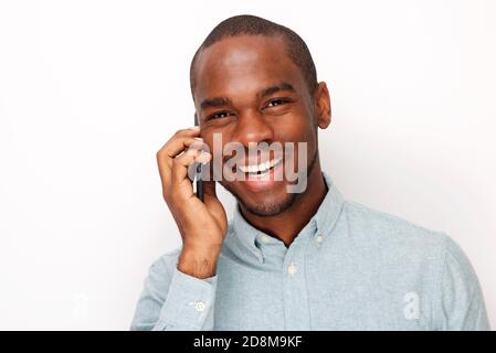 Close up portrait of smiling young black man talking with mobile phone against isolated white background Stock Photo