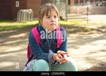 A portrait of trisomie 21 child girl outside on a school playground Stock Photo