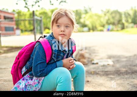 A portrait of trisomie 21 child girl outside on a school playground Stock Photo