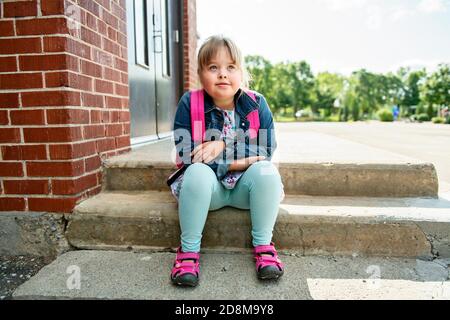 A portrait of trisomie 21 child girl outside on a school playground Stock Photo