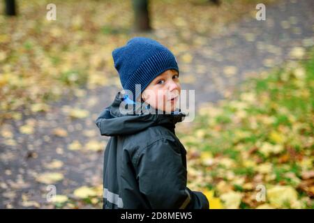Cute little boy walking in the Park on an autumn day. Turn around Stock Photo