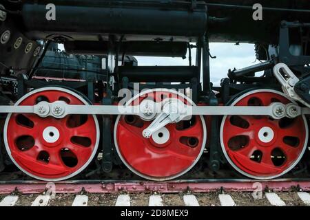 Old Russian train has been made on 1900. Old Russian locomotive. Steam locomotive with red wheels. Retro locomotive on rails. Stock Photo