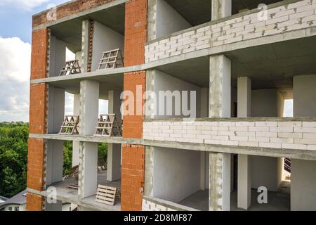 New apartment building facade with many windows and flat rooms under construction. Stock Photo