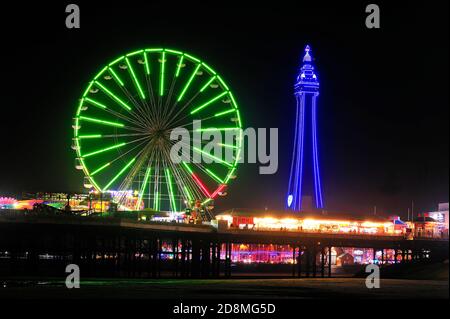 The many colours of Blackpool Tower and the Ferris wheel at night during the annual illuminations Stock Photo