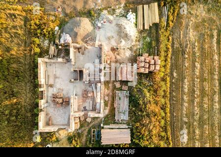 Top down aerial view of a house under construction with concrete foundament and brick walls. Stock Photo