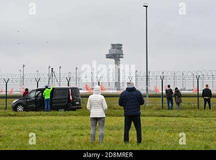 31 October 2020, Brandenburg, Schönefeld: Onlookers stand at the fence of the southern runway near the tower of the capital airport Berlin Brandenburg 'Willy Brandt' (BER). The airport was opened on 31.10.2020 after a long delay. Photo: Patrick Pleul/dpa-Zentralbild/ZB Stock Photo