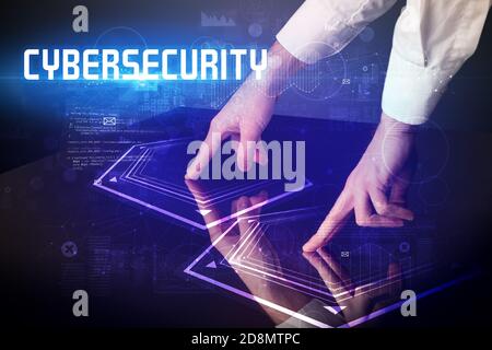 Hand touching digital table with CYBERSECURITY inscription, new age security concept Stock Photo