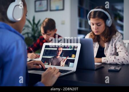 Online school lesson. Children learning via internet with laptops at home. Stock Photo