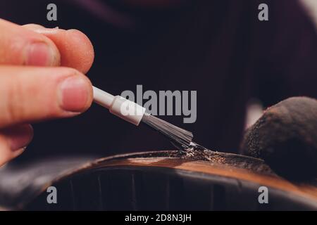glue application with a brush, shoe repair. Stock Photo