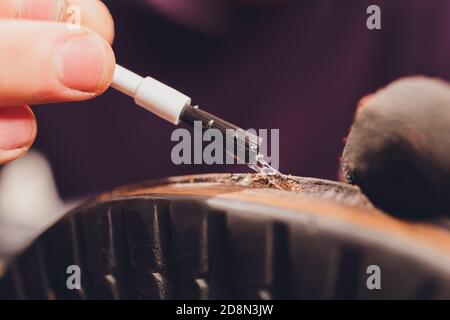glue application with a brush, shoe repair. Stock Photo