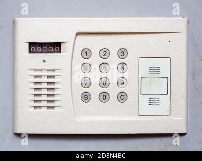 White metal intercom on a light gray wall. Close-up photo Stock Photo