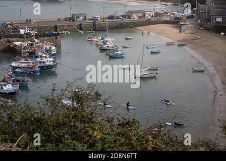 Fishing boats moored in Newquay Harbour, Cornwall with paddle boards. Stock Photo