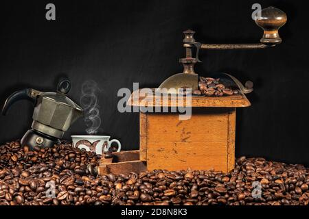 https://l450v.alamy.com/450v/2d8n8k3/old-manual-coffee-grinder-italian-coffee-maker-and-a-cup-on-a-pile-of-roasted-coffee-beans-with-empty-blackboard-in-the-background-2d8n8k3.jpg