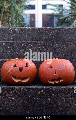 Carved Halloween pumpkins in the entrance of a house Stock Photo