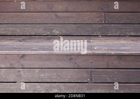 Close-up of a veranda wall made of brown and gray wooden planks with relief as a background for an autumn decor or billboard. Stock Photo