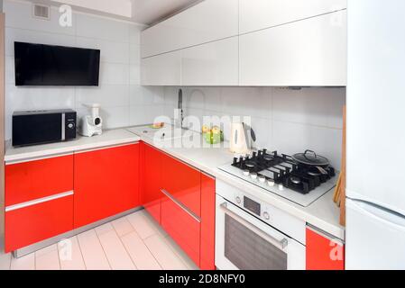 Upscale Maple Red and Smoky White kitchen in luxury home with stoneware counter top flat wooden panels design. Stock Photo