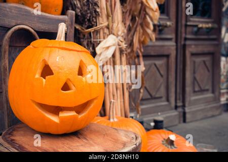 The symbol of Halloween pumpkin carved with a variety of emotions on the chair, selective focus. Stock Photo