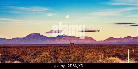 Early morning landscape in New Mexico, with mountains and a setting Moon. Stock Photo