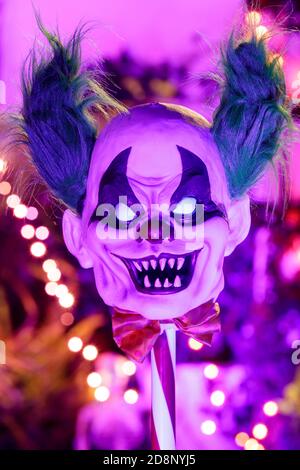 Killer Clown Face on Pole Decorating Halloween Yard at Night