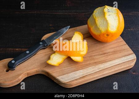 Peeling Strips of Orange Zest: Peeling an orange with a paring knife Stock Photo