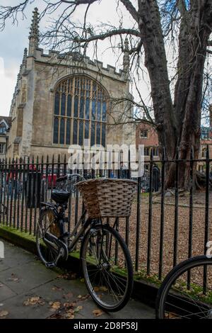 a bicycle with a vintage basket on the front for shopping and books owned by a student leaning on railings in the university city of cambridge. Stock Photo