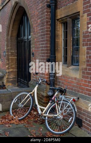 traditional student cycle or bicycle leaning on a wall in the university city of cambridge in a typical scene