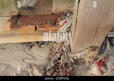 Close up sea wall coastal barrier in wood bolted together metal