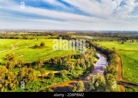 Macquarie river flowing trough Dubbo city in Australian Great Western plains - aerial view in bright sun light over irrigated agriculture farms. Stock Photo