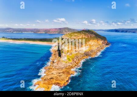 Scenic sandstone cliff of Barrenjjoey head on Sydney pacific coast aerial view from open Pacific ocean. Stock Photo
