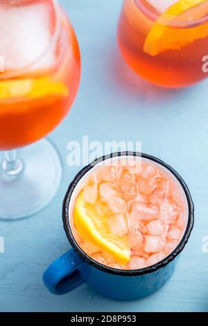 Different glasses of classic italian aperitif aperol spritz cocktail with slice of orange on a blue table Stock Photo