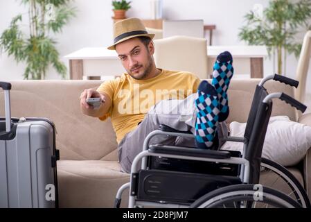 Young man in wheel-chair preparing for departure Stock Photo