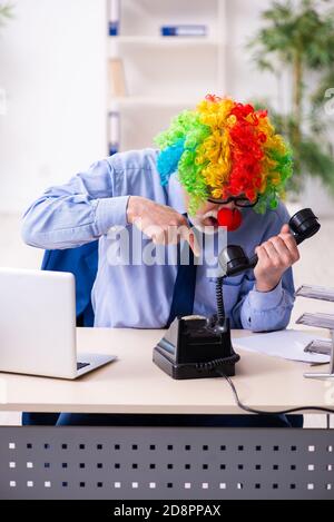 Aged businessman clown working in the office Stock Photo