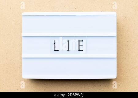 White lightbox with word lie on wood background Stock Photo