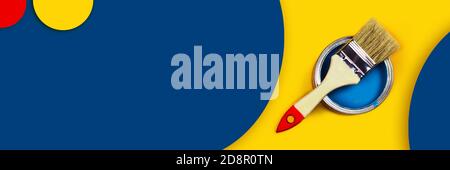 Abstract repair web-banner. One can of paint with a paintbrush on a yellow and classic blue background with colored circles made from paper. Stock Photo