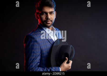 Closeup portrait of young handsome confident serious bearded Indian man, businessman with stylish hairstyle, wearing shirt, checkered suit standing ag Stock Photo