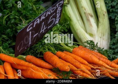 fresh carrots, celery and parsley on a fruit and vegetable grocers stall at a marketplace in holt, norfolk Stock Photo