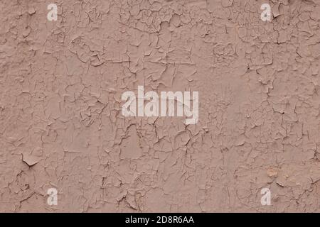 Brown texture of cracked paint on a metal wall. Peeling paint on a concrete wall. Beige painted abstract background, grunge surface, natural pattern, Stock Photo